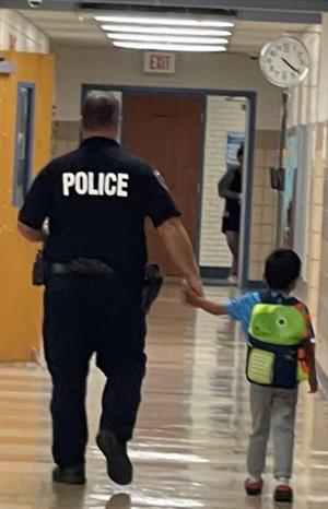police officer walking with small child